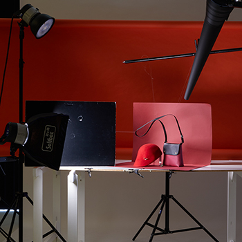 Making Of Produktfotografie Fashionaufnahme Handtasche Hut auf Rot