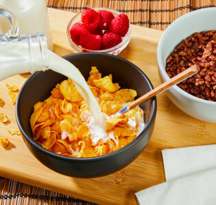 Frühstück Cornflakes Milch Himbeeren im Ambiente