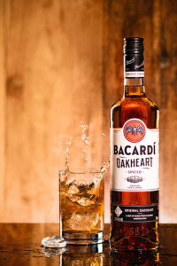 Rum mit Glas und Splash vor Holzambiente